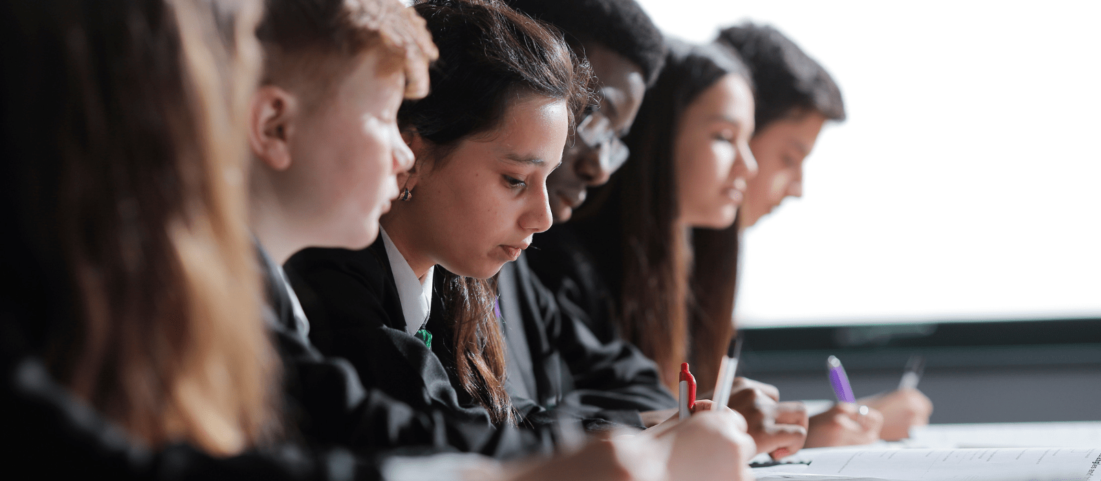 students sitting at desk writing